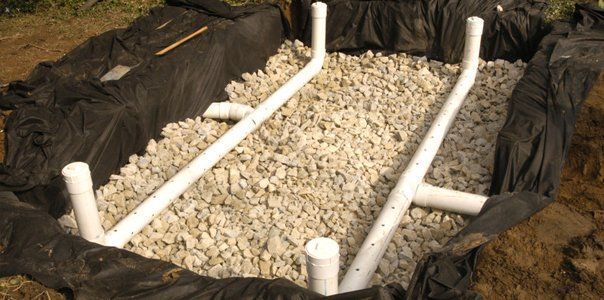 PVC pipes laid in a gravel-filled trench for drainage or septic installation