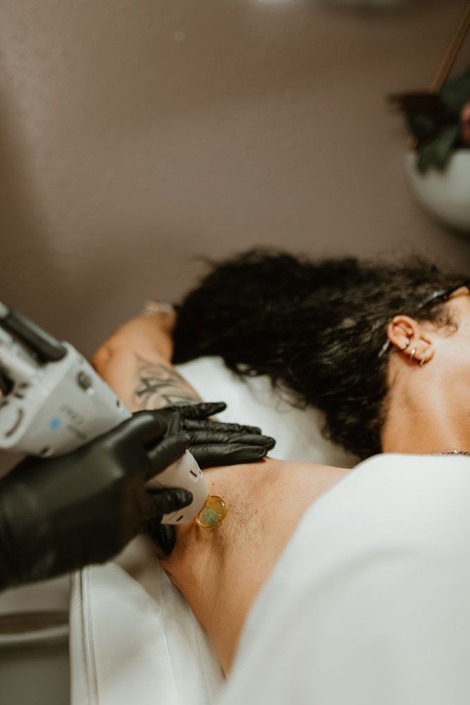 A woman is getting a laser treatment on her shoulder.