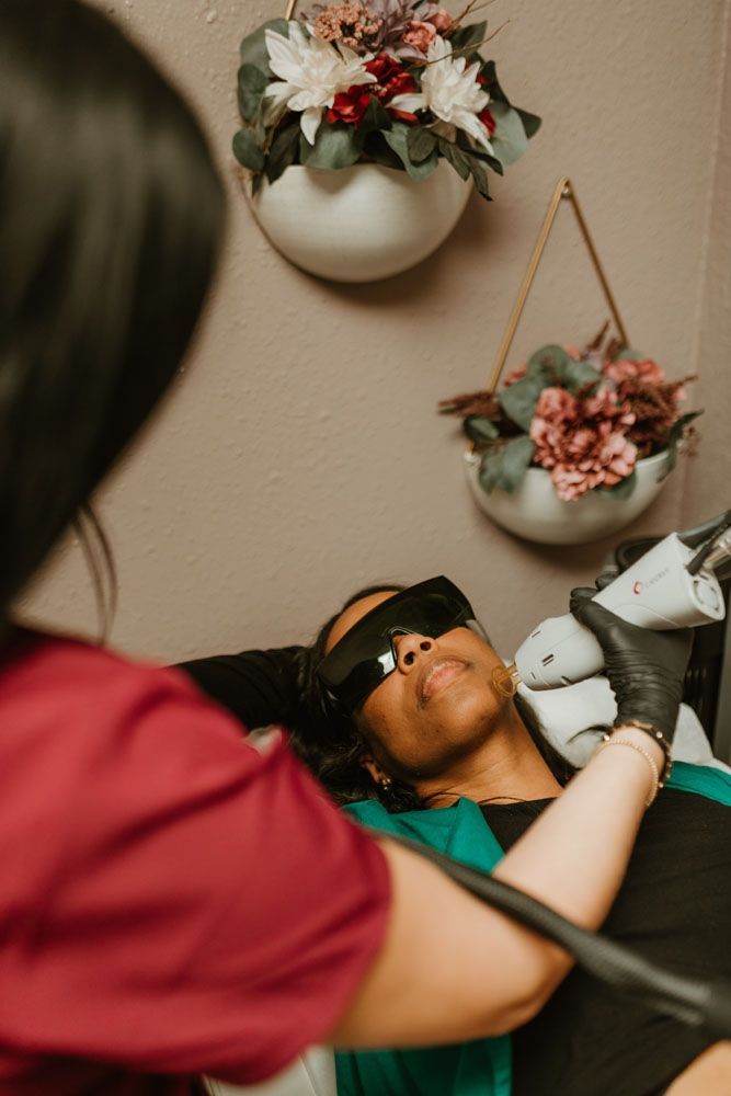 A woman is getting a laser hair removal treatment on her face.