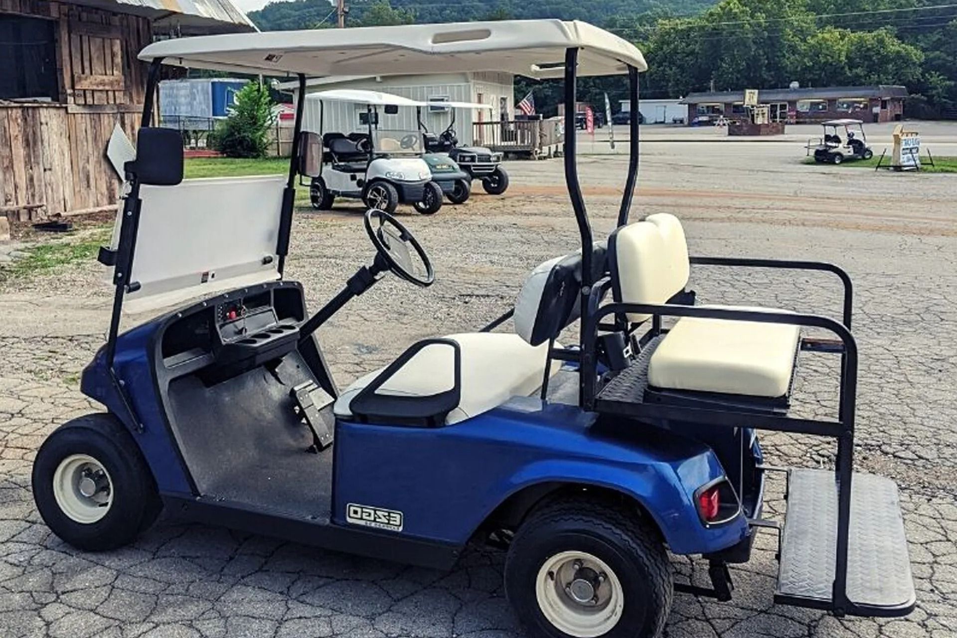 A blue golf cart is parked in a parking lot