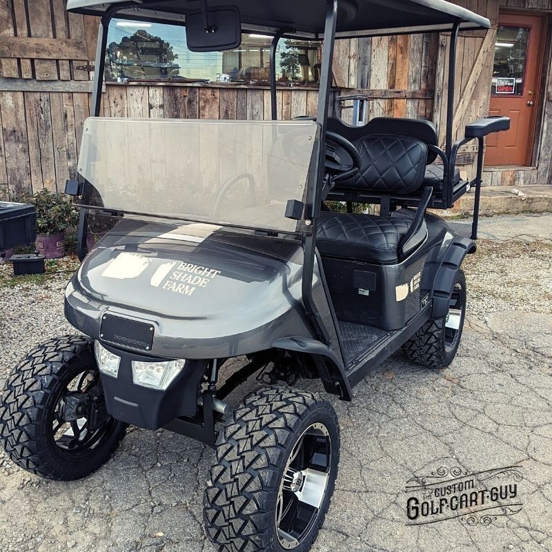 A golf cart is parked in front of a wooden building