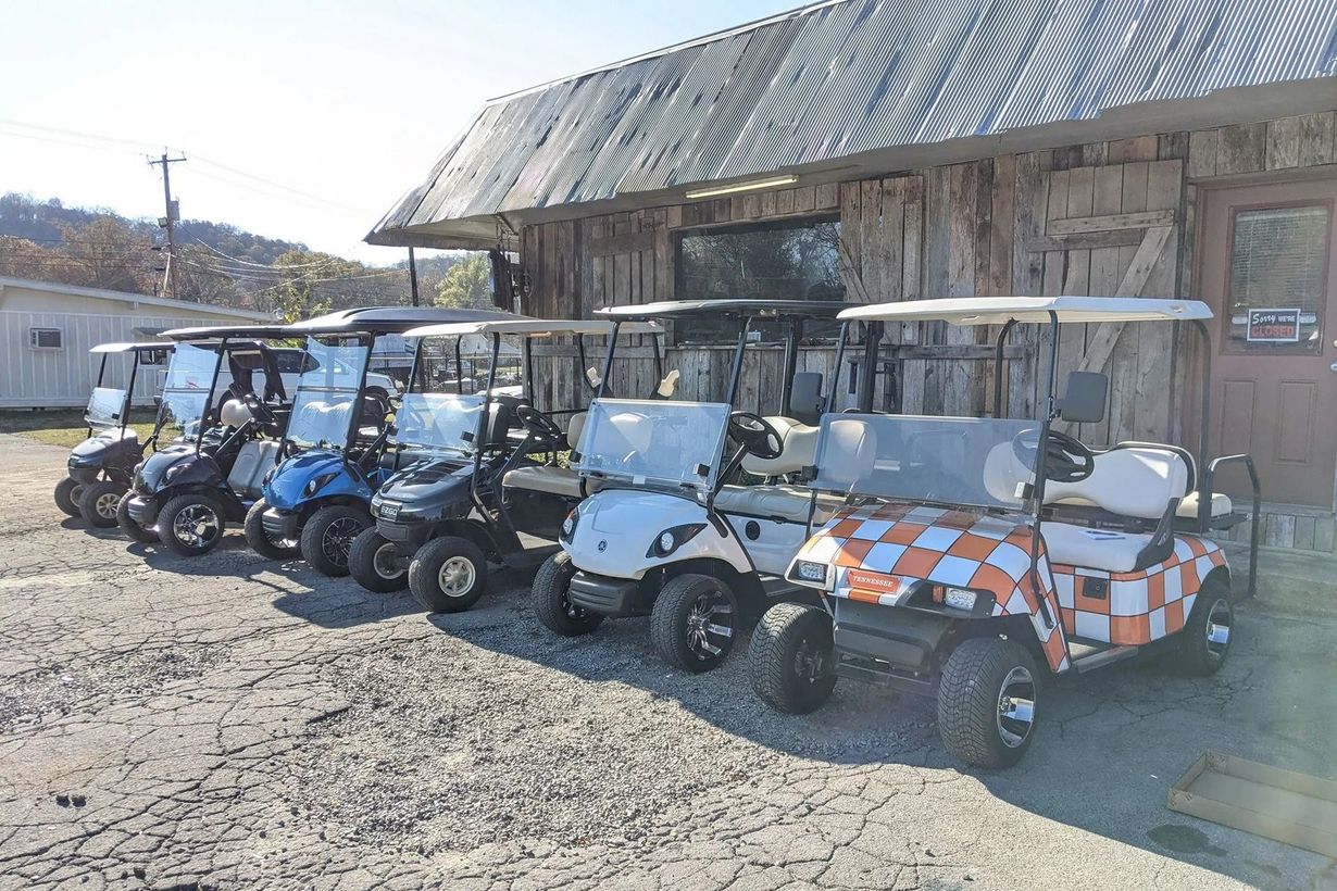 A row of golf carts parked in front of a building.
