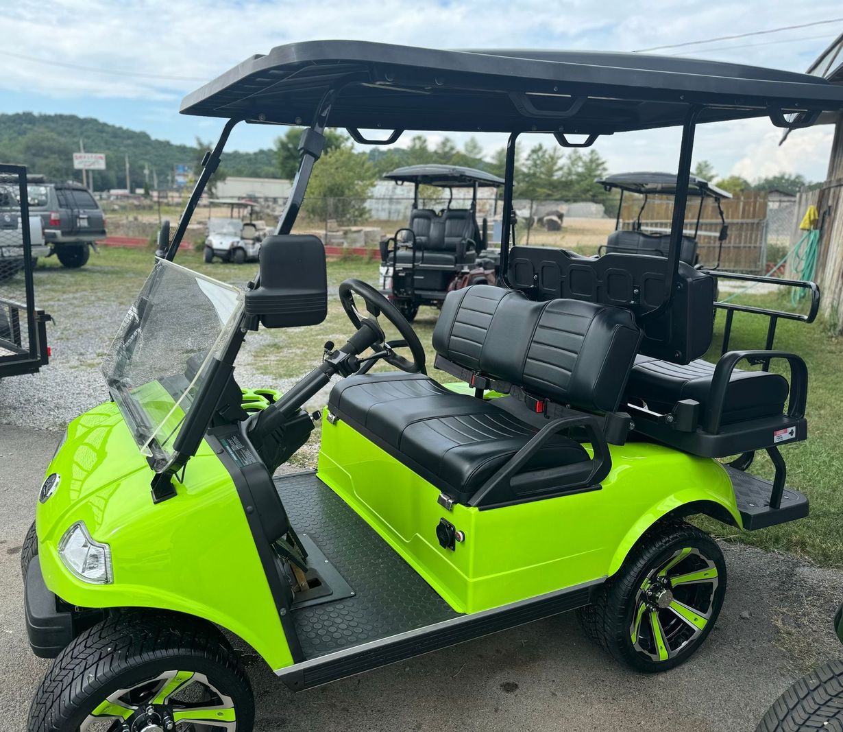 A neon green golf cart is parked in a parking lot.
