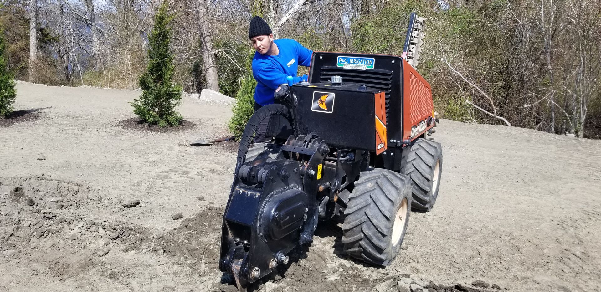 A man is driving a tractor on a dirt road.