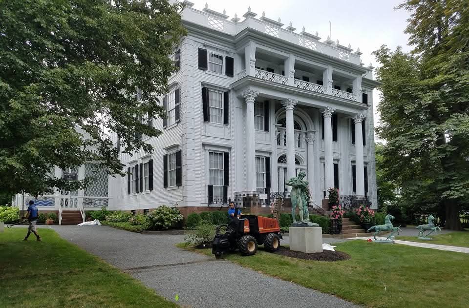 A tractor is parked in front of a large white building