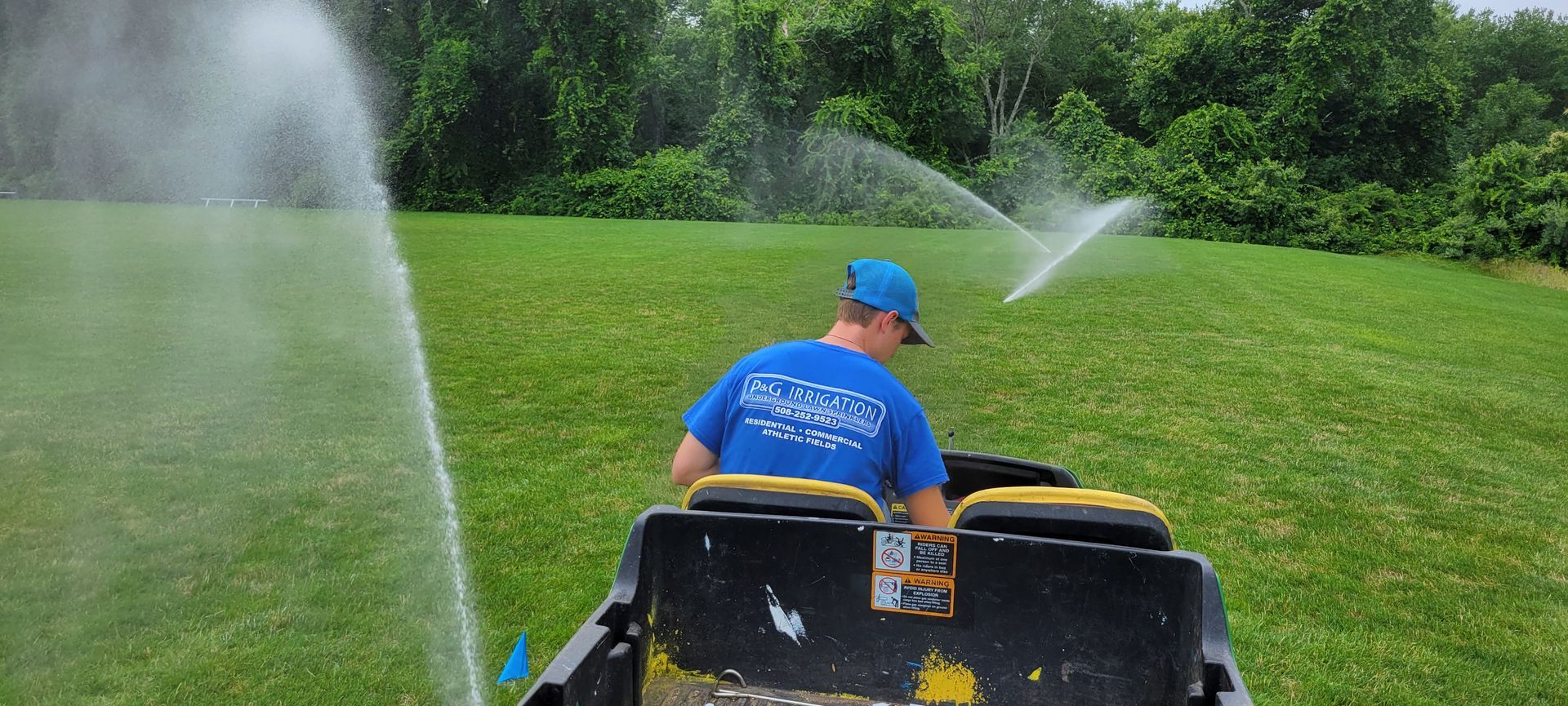 A man is riding a lawn mower through a grassy field.