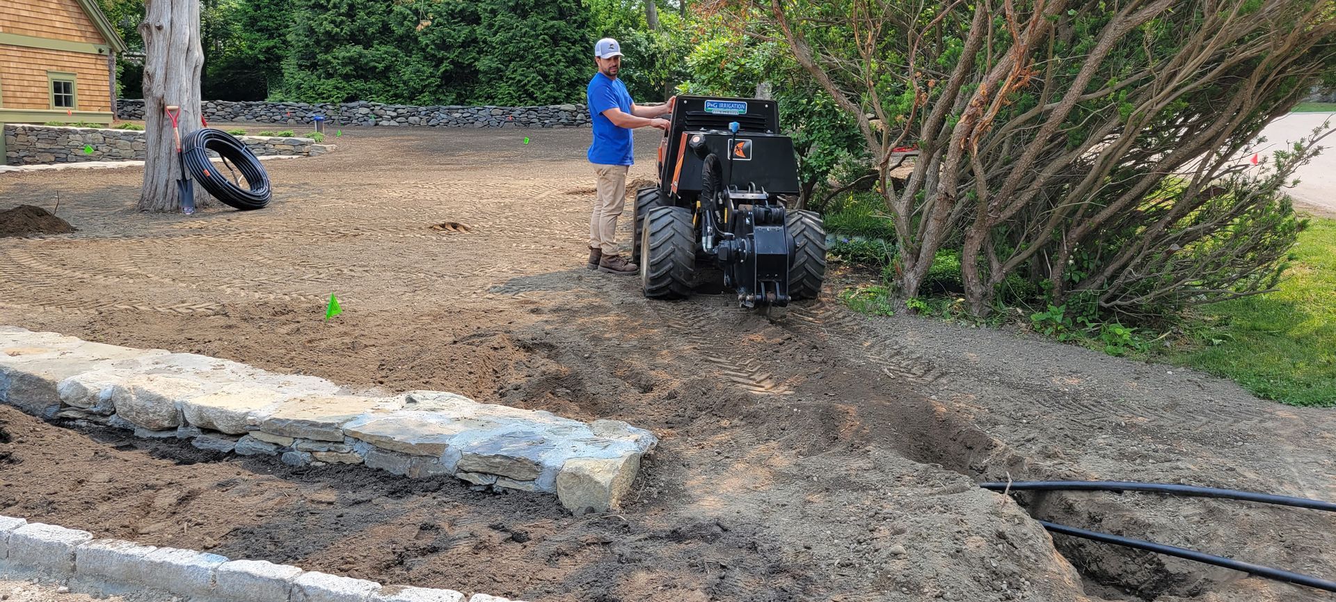 A man is using a tractor to dig a hole in the ground.
