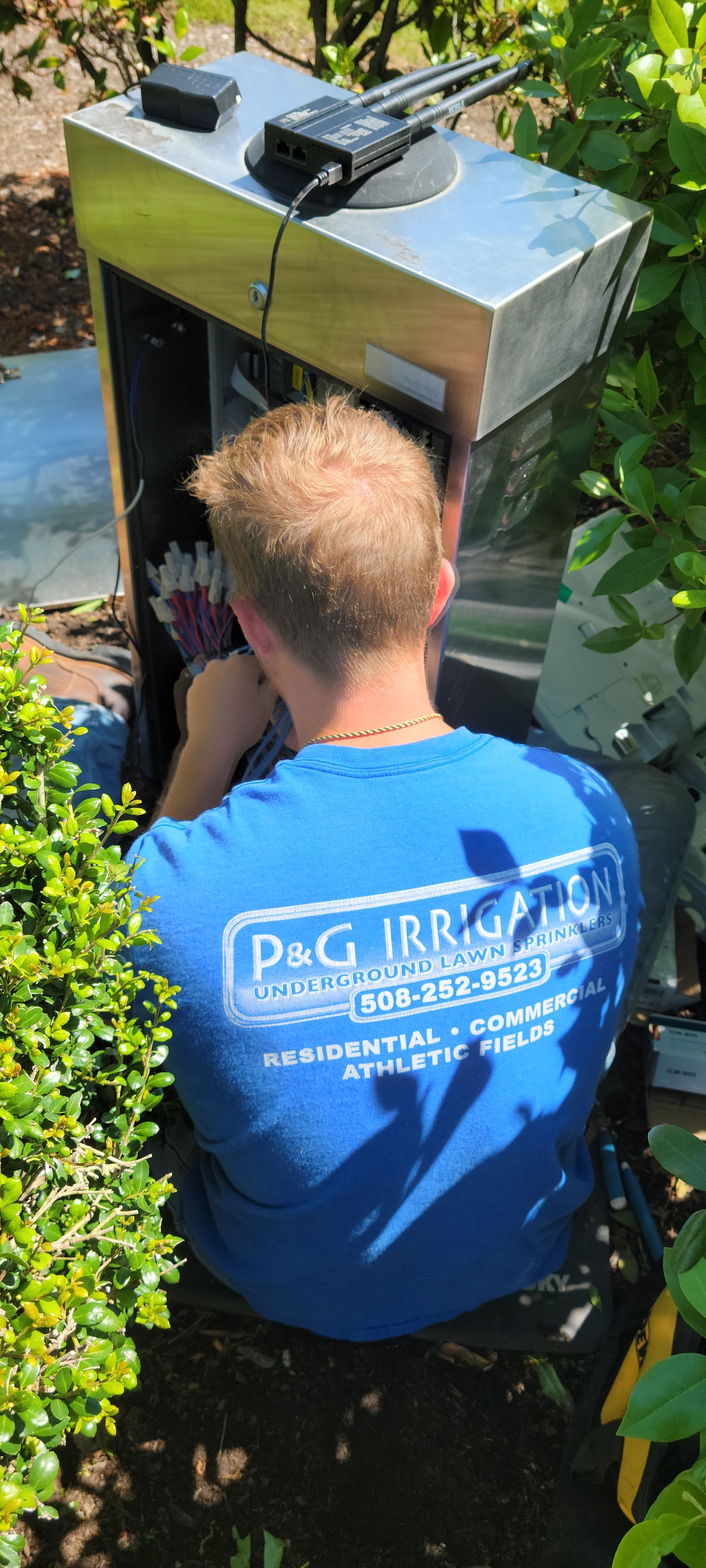 A man in a blue shirt is working on a machine.