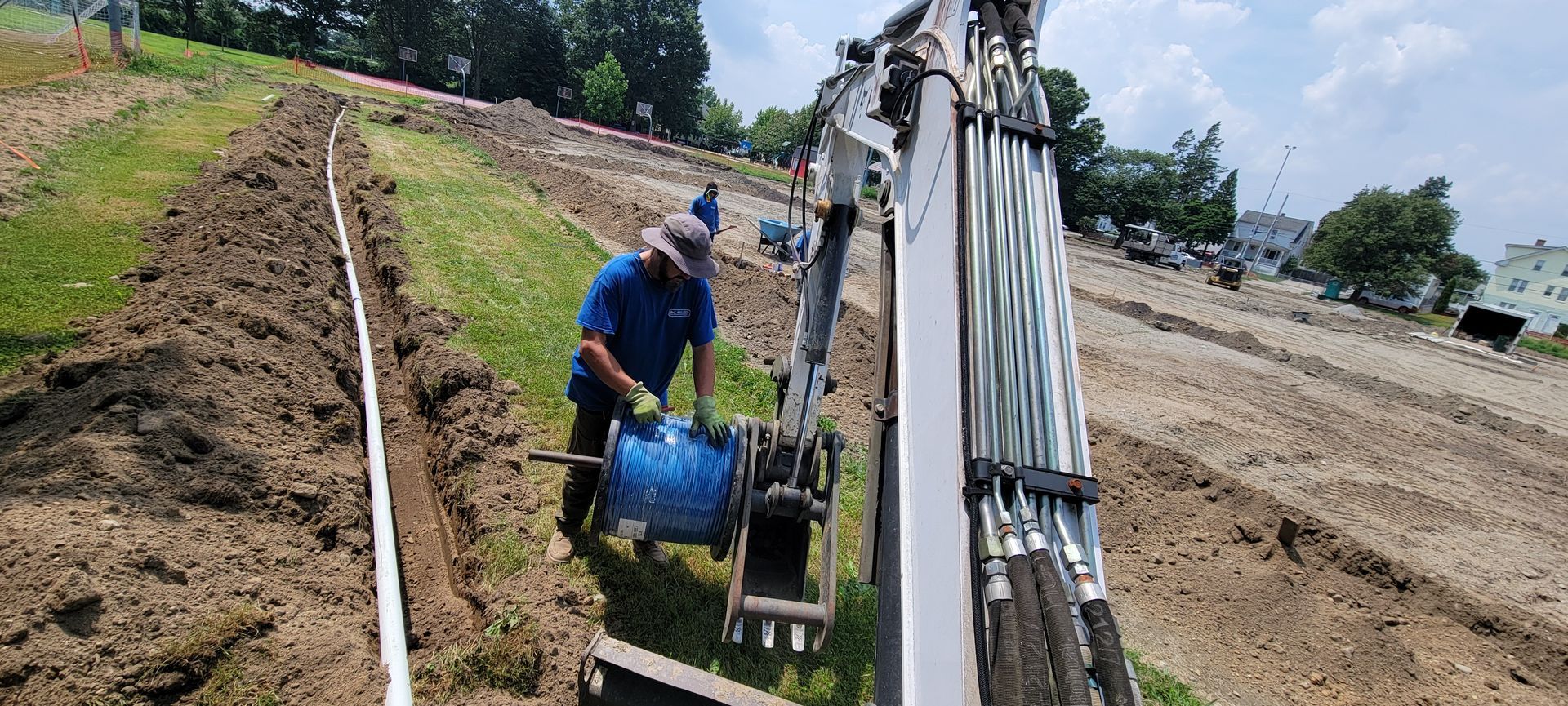 A man is working on a pipe in the dirt.