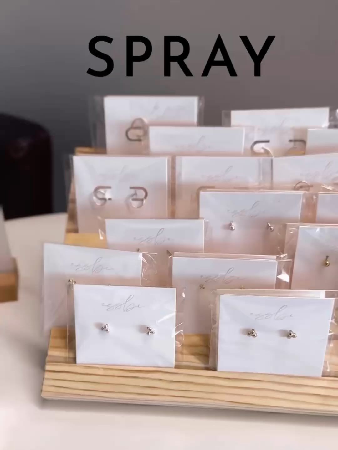 A display of earrings with the word spray above them