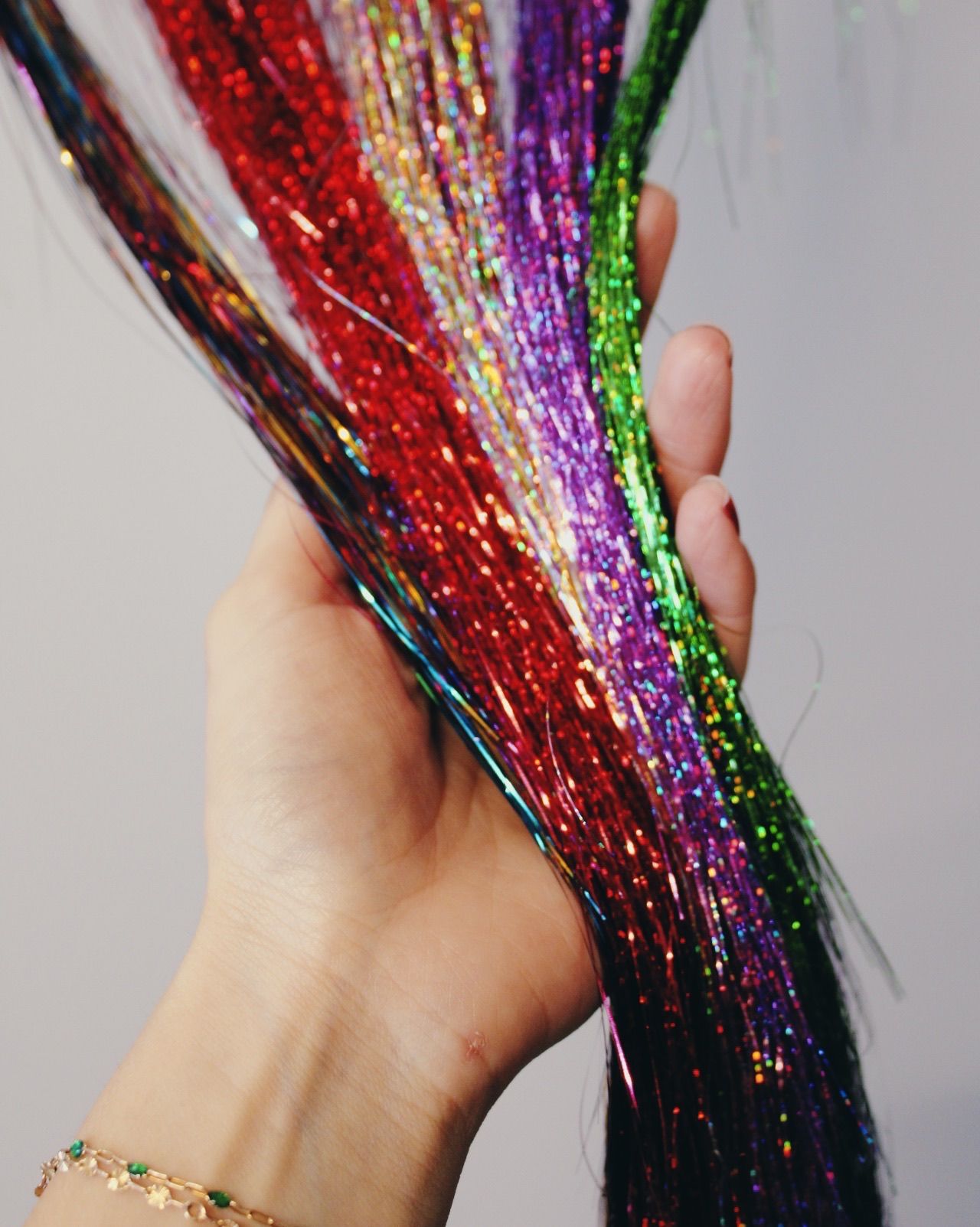 A person is holding a bunch of tinsel in their hand