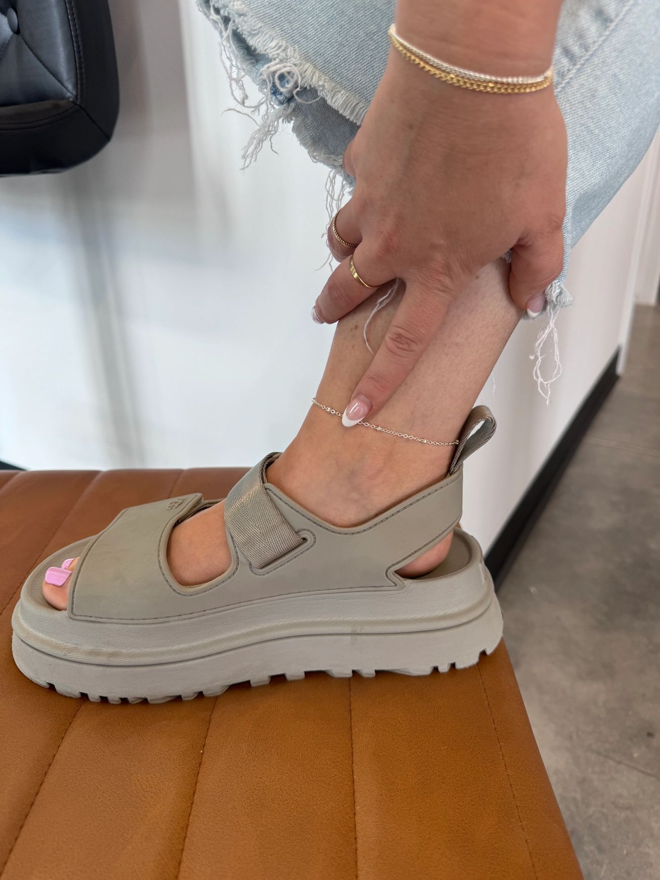 A woman is wearing a pair of sandals and an anklet.