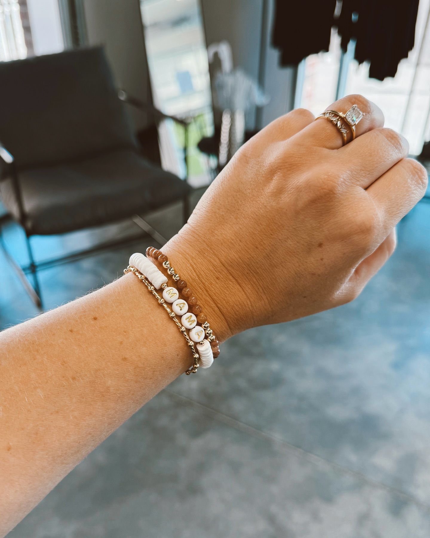 A woman is wearing a bracelet and a ring on her wrist.