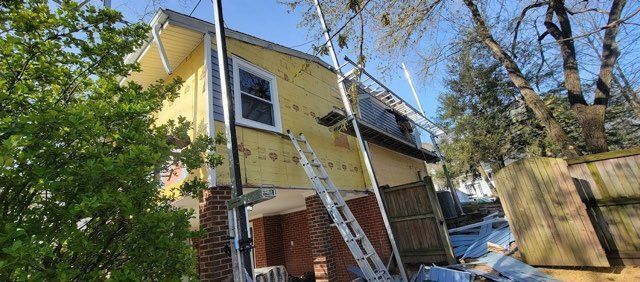 A house with a ladder attached to it is being remodeled.