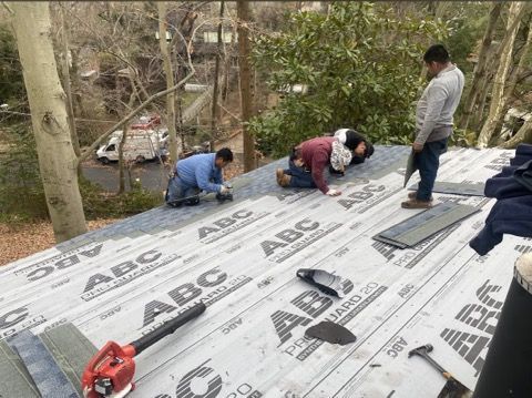 A group of men are working on a roof.