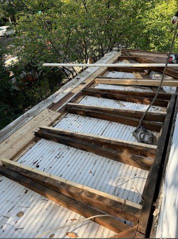 A wooden deck is being built on top of a metal roof.