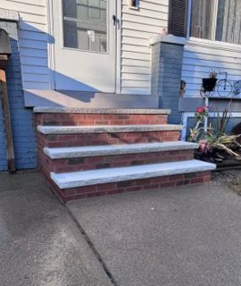 A set of brick steps leading up to a blue house.