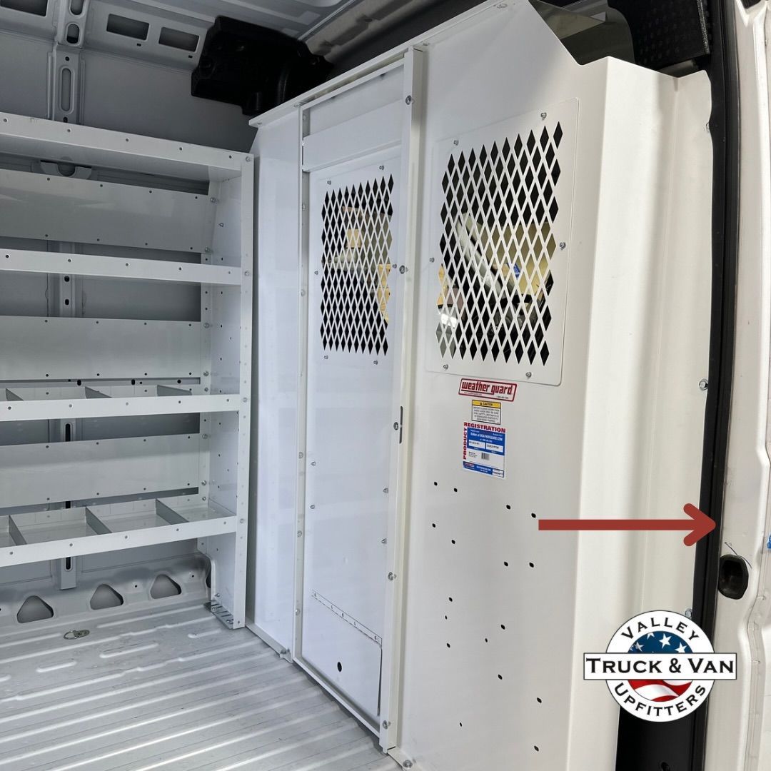 White shelving and cabinet inside a cargo van; red arrow pointing to van door seal.