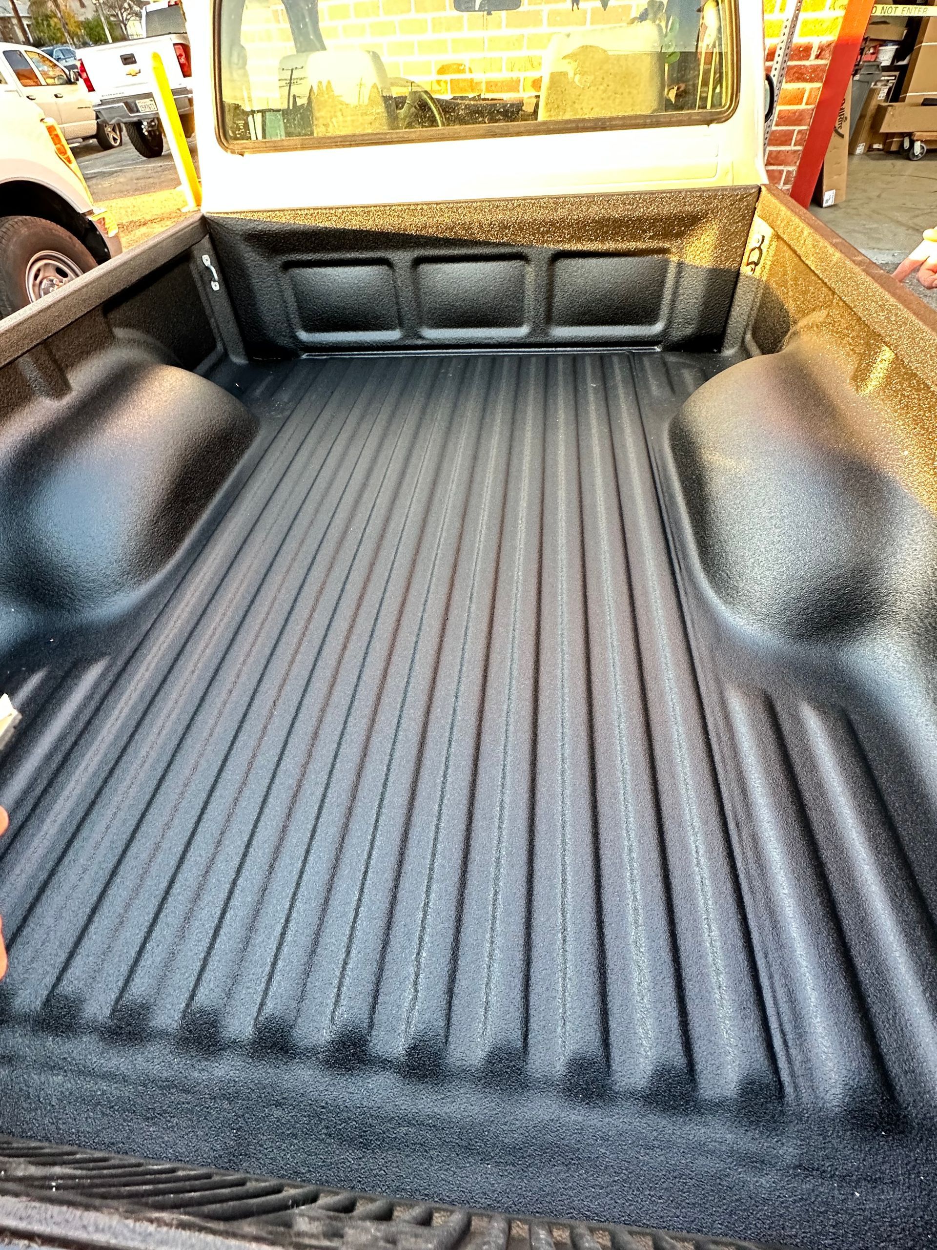 The black, textured spray-in bed liner covering the interior bed of a pickup truck.