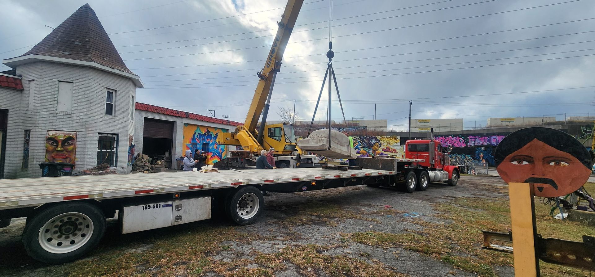 A flatbed truck is being towed by a crane.