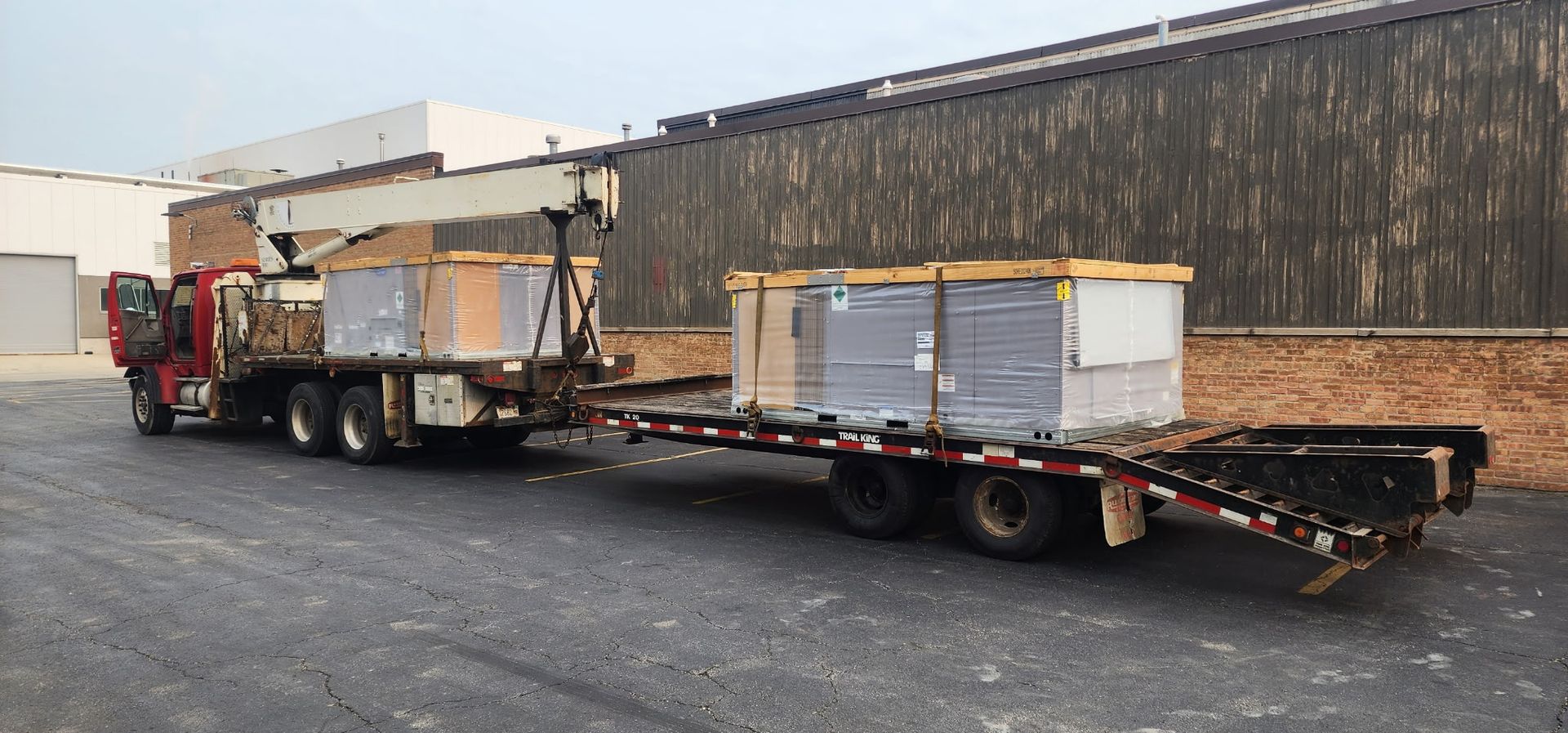 A semi truck is carrying boxes on a trailer in a parking lot.