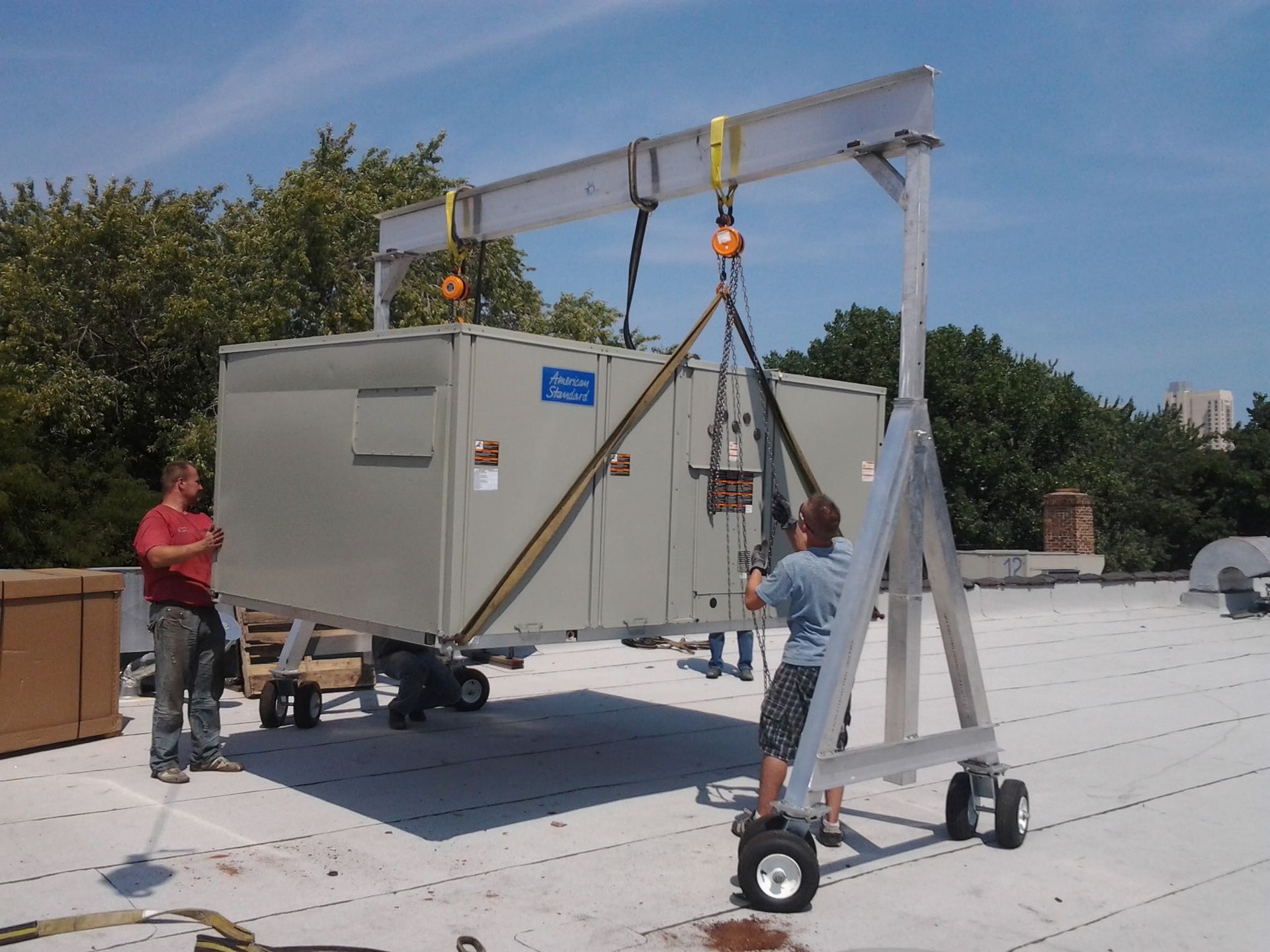 A man is lifting a large box on a roof