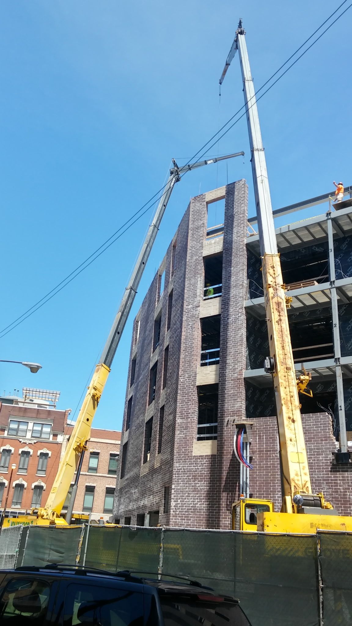 A building under construction with two cranes in front of it