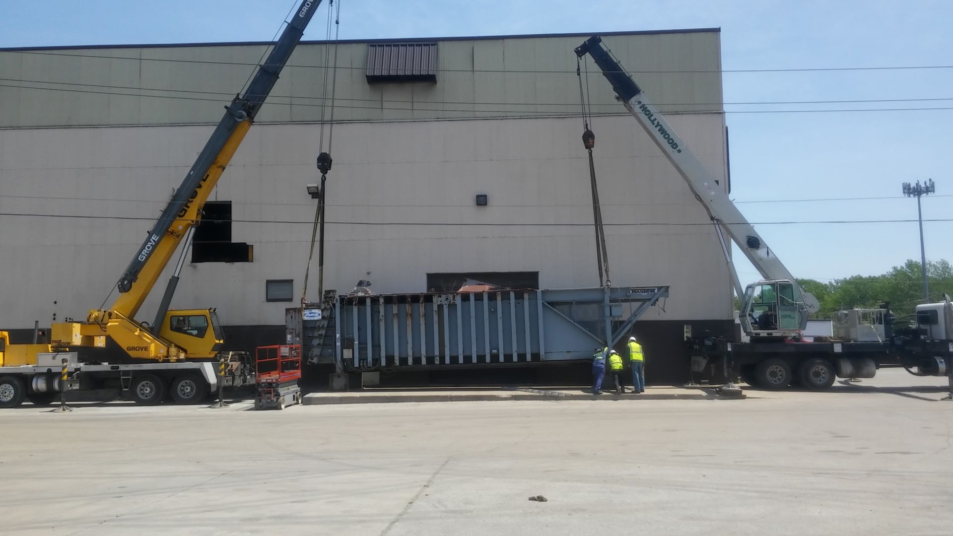 A crane is lifting a large object in front of a building
