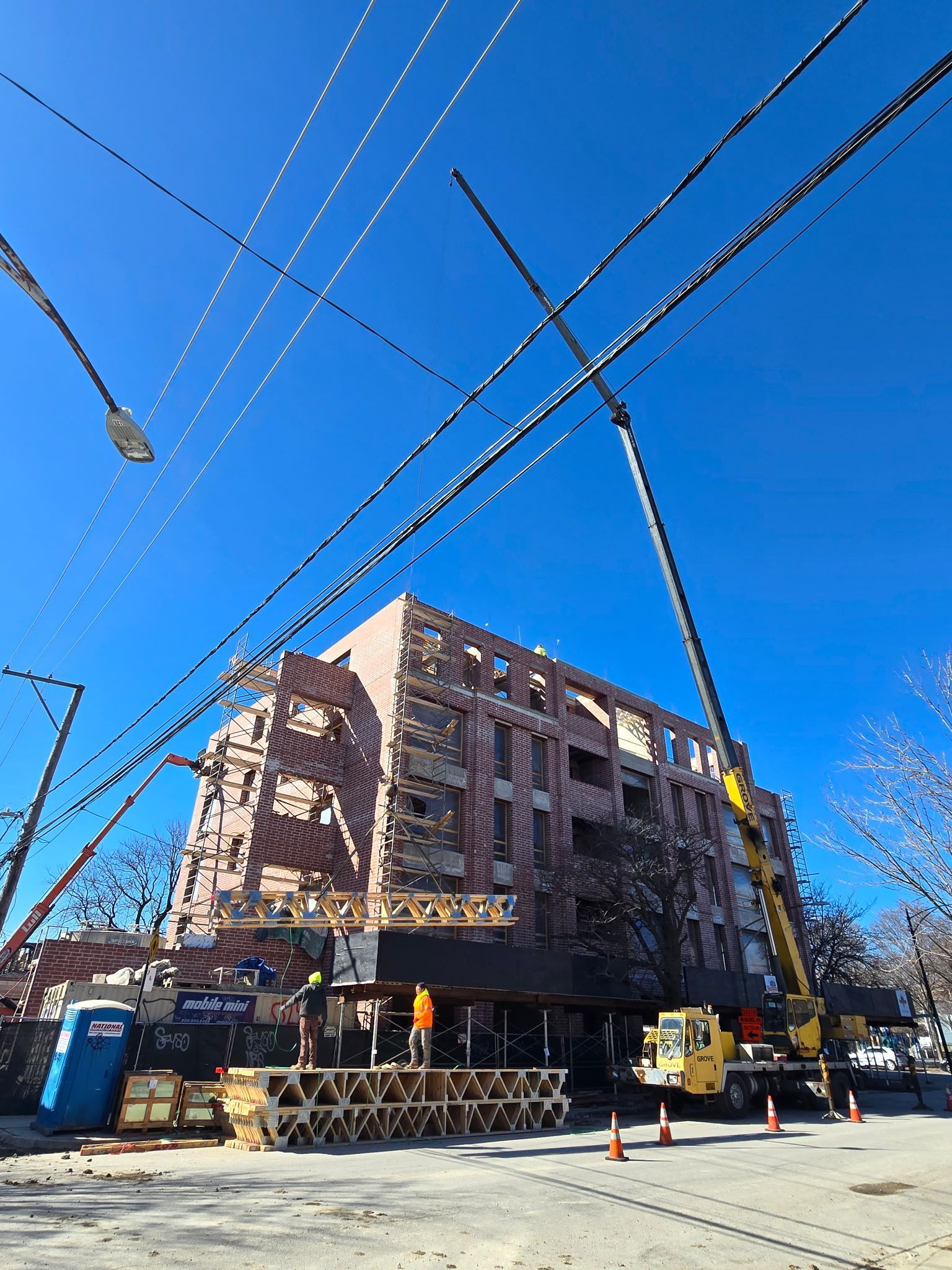 A large building under construction with a crane in front of it