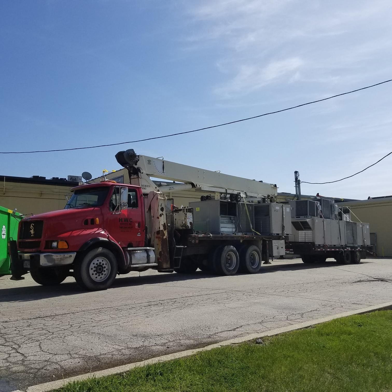 A red truck with a crane on the back of it