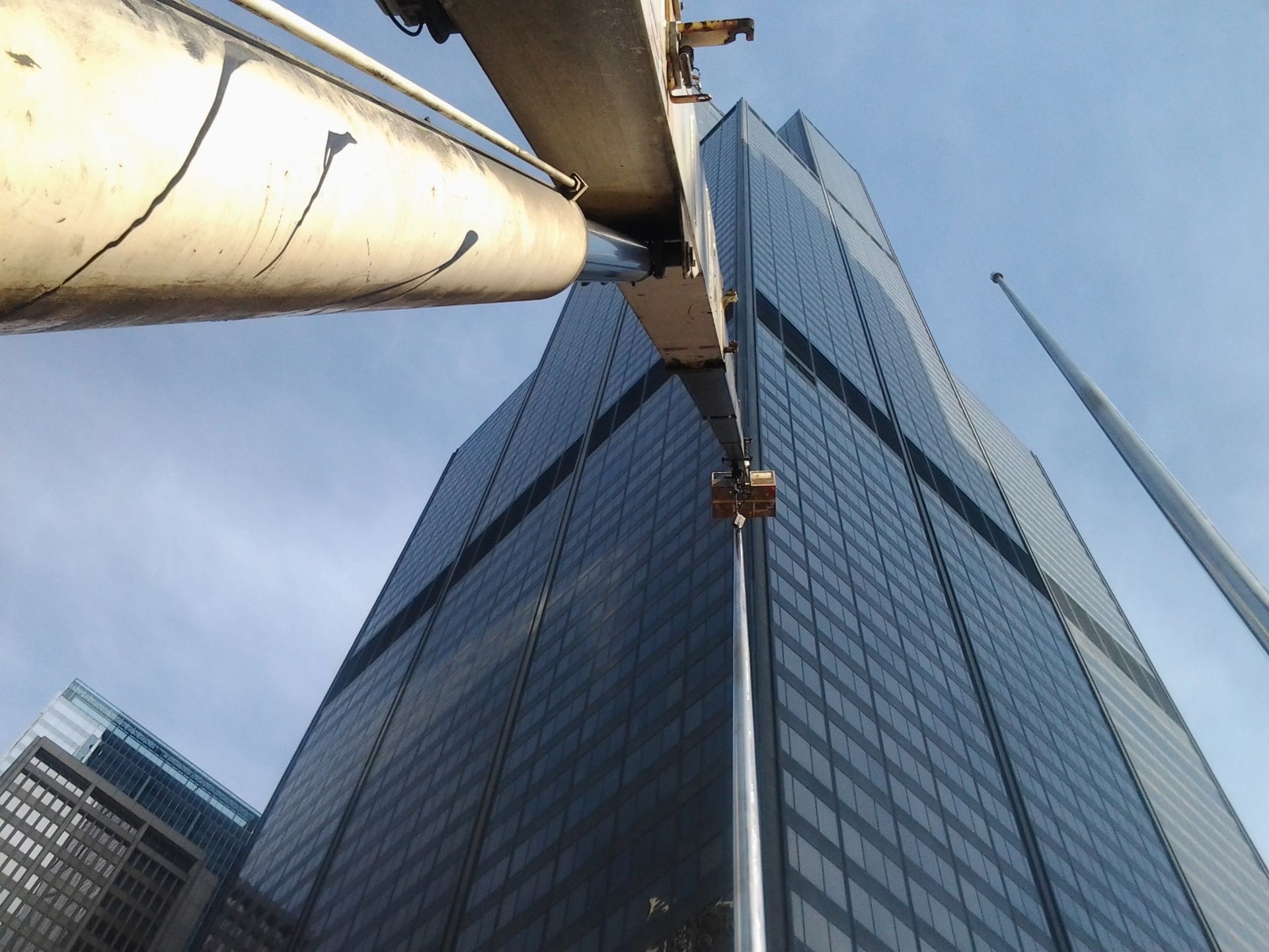 Looking up at a tall building with a crane in front of it