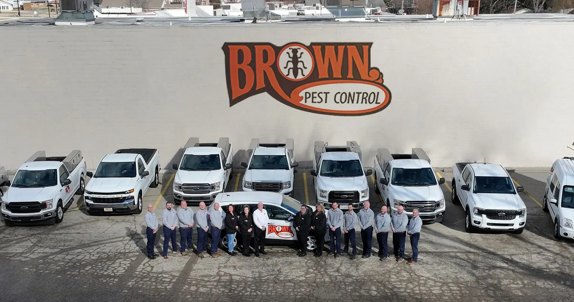 Brown Pest Control team with company trucks in front of the building.