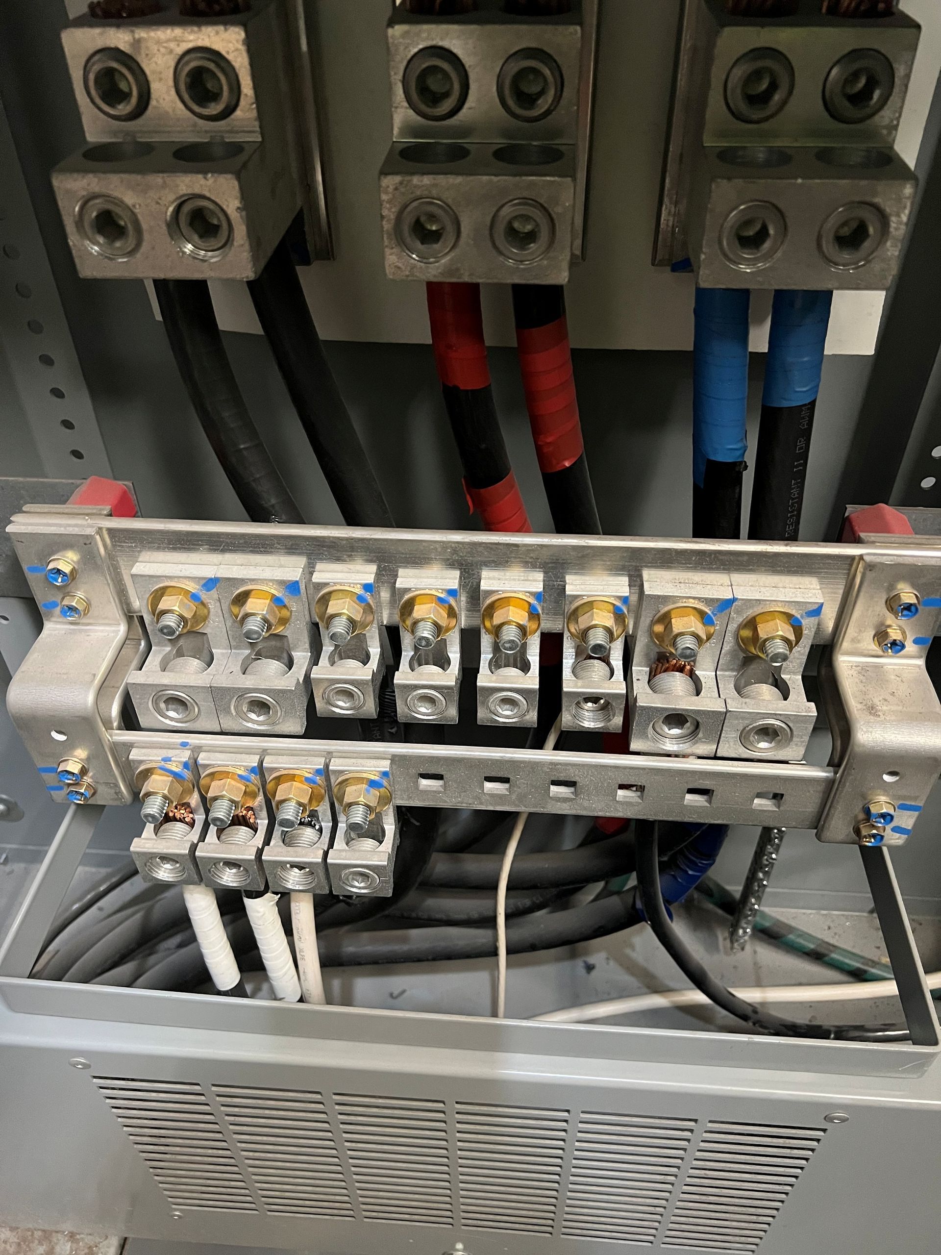 Electrical panel with cables connected to terminals, various colored wires and a cooling vent.