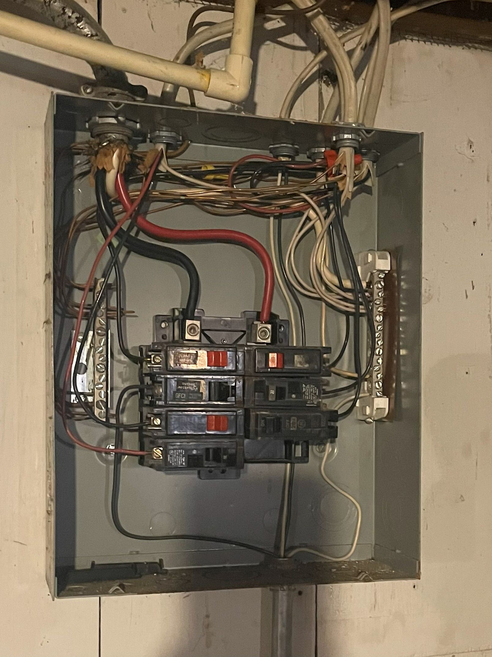 Open electrical panel with numerous wires and circuit breakers.