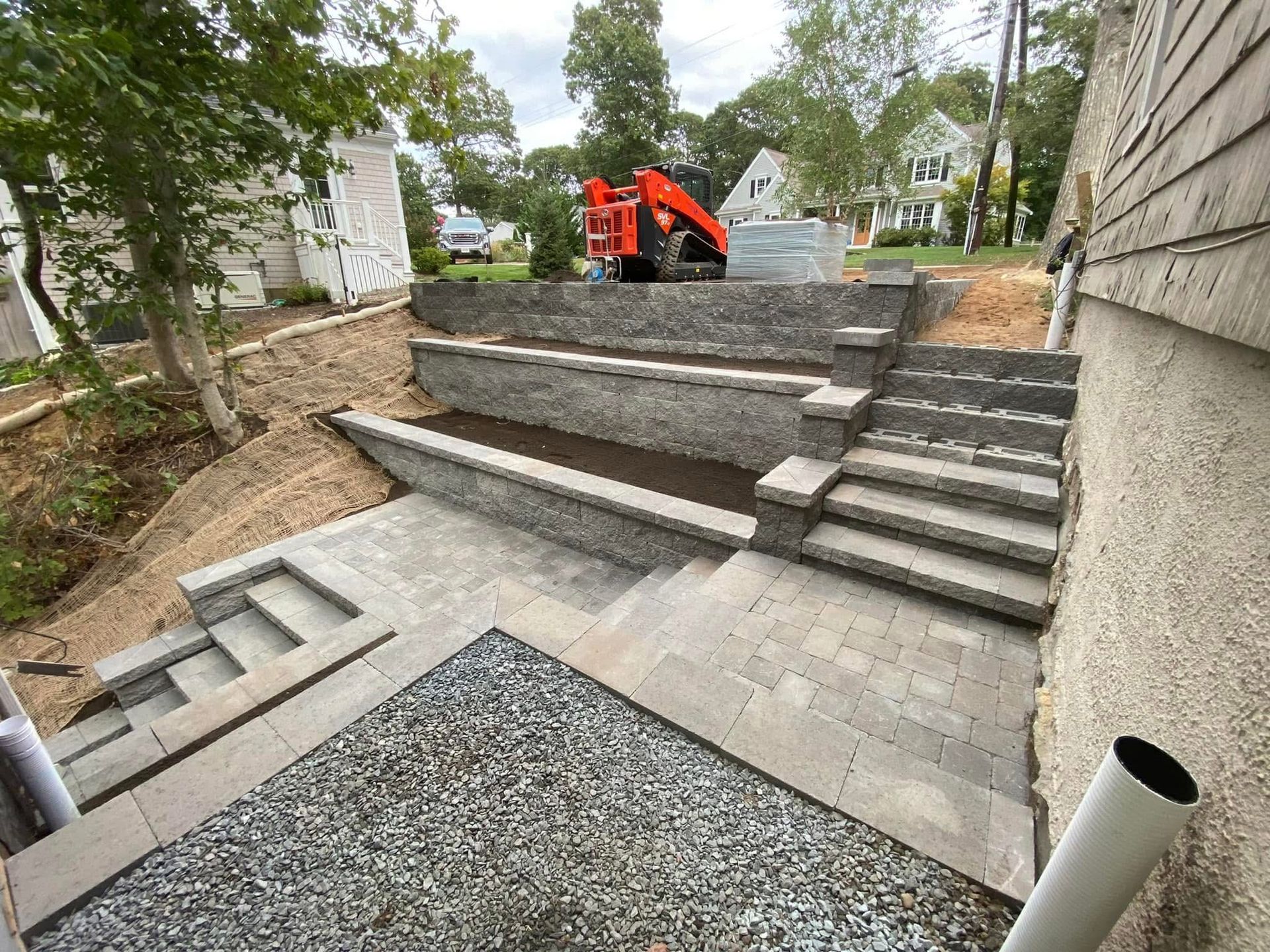 A staircase is being built next to a house with a tractor in the background.