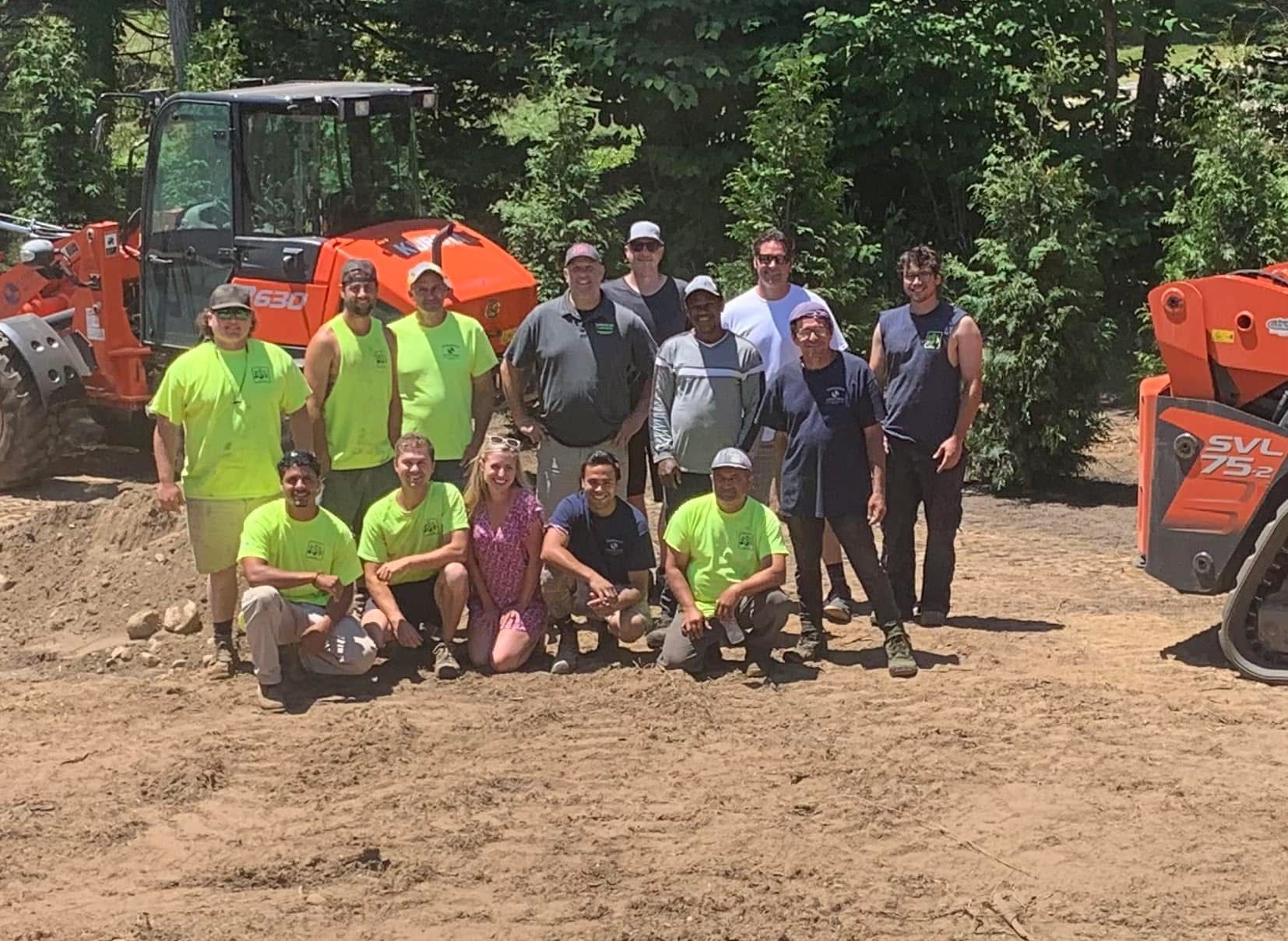 A group of people are posing for a picture in a dirt field.