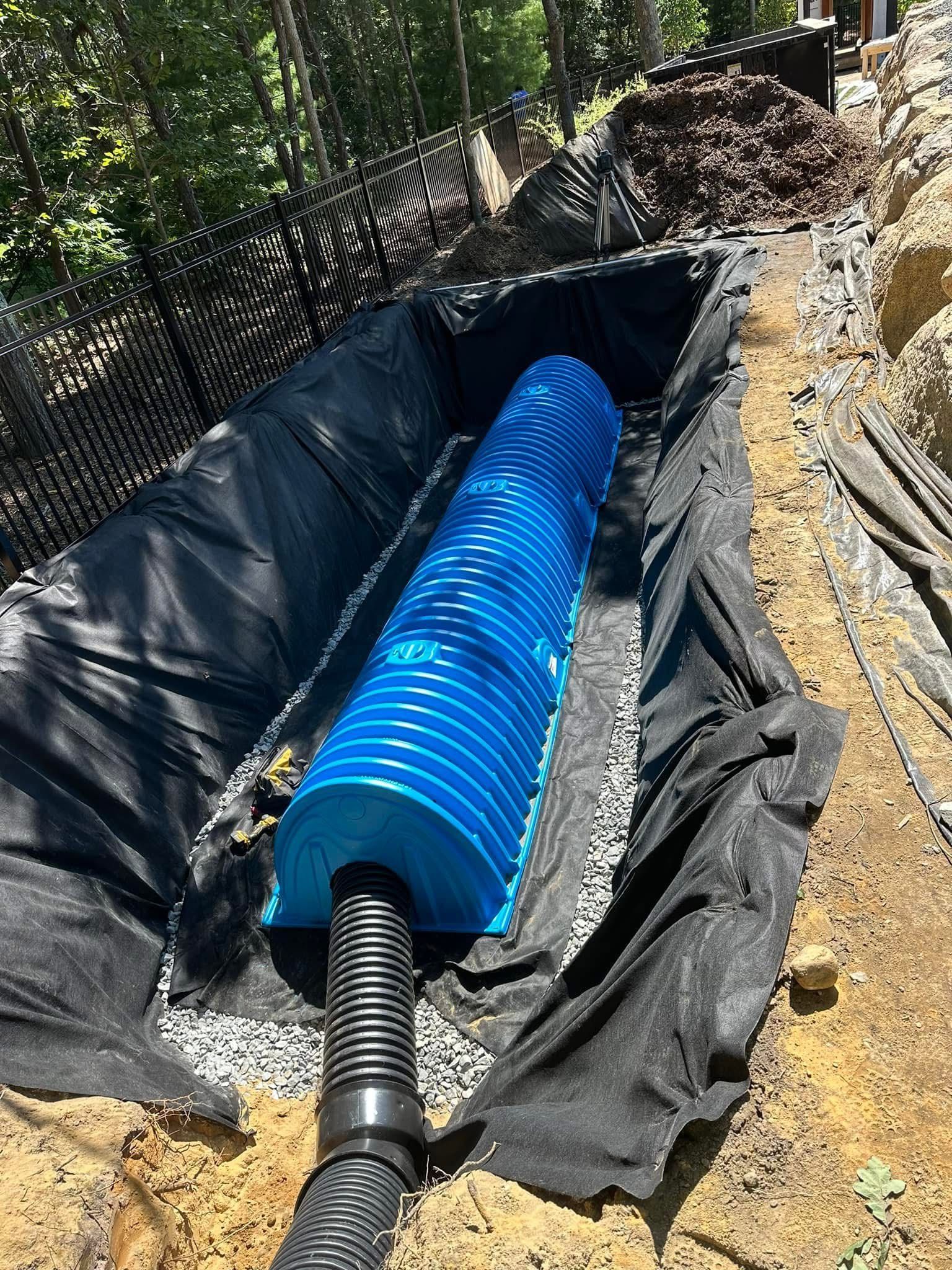 A blue pipe is sitting in a hole in the ground.