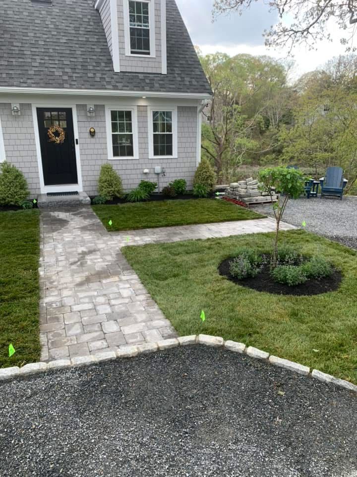 A house with a walkway leading to the front door and a driveway.