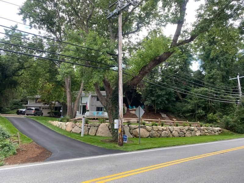 A house is sitting on the side of the road next to a road.