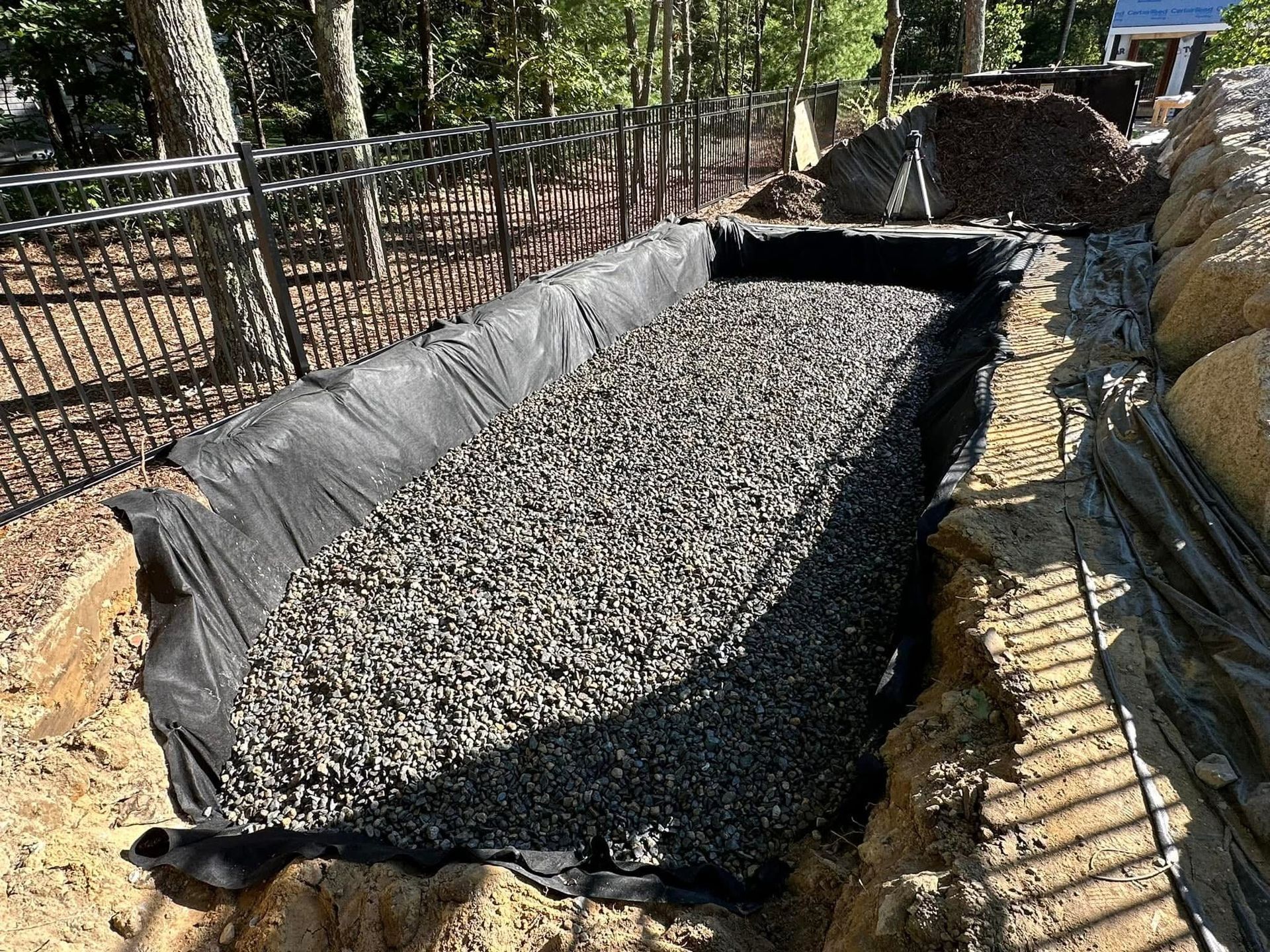 A large pile of gravel is sitting on top of a pile of dirt.
