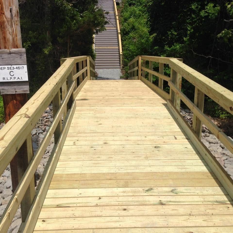 A wooden bridge with a sign that says ' stairs ' on it