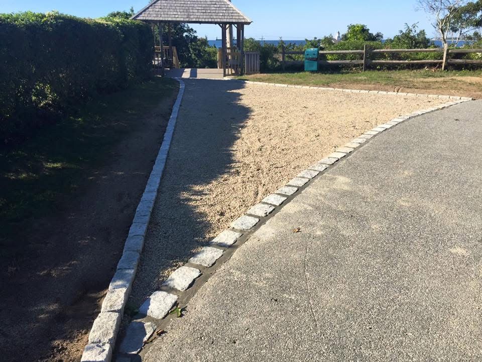 A path with a wooden gazebo in the background