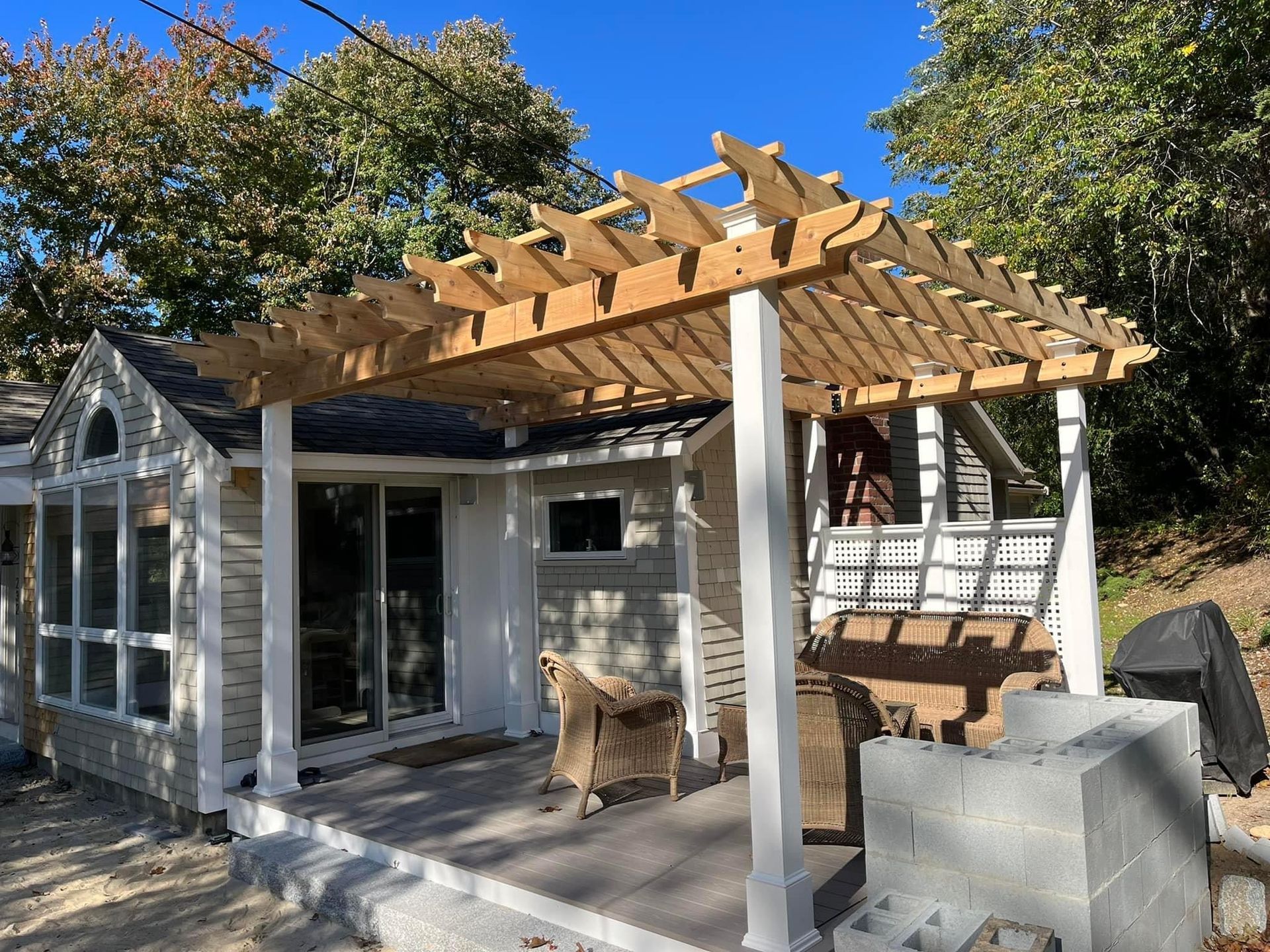A house with a wooden pergola on top of it.