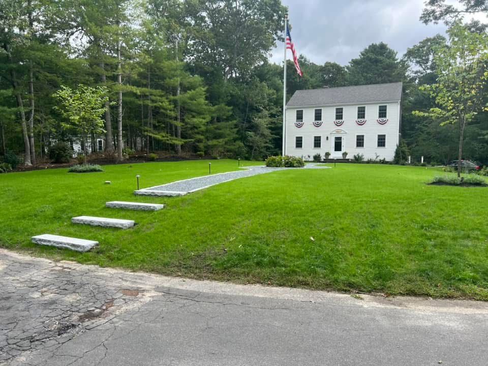 A large white house with a large lawn in front of it.
