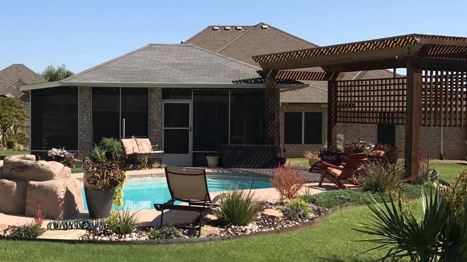 Backyard patio with swimming pool, lounge chairs, pergola, and landscaped garden.