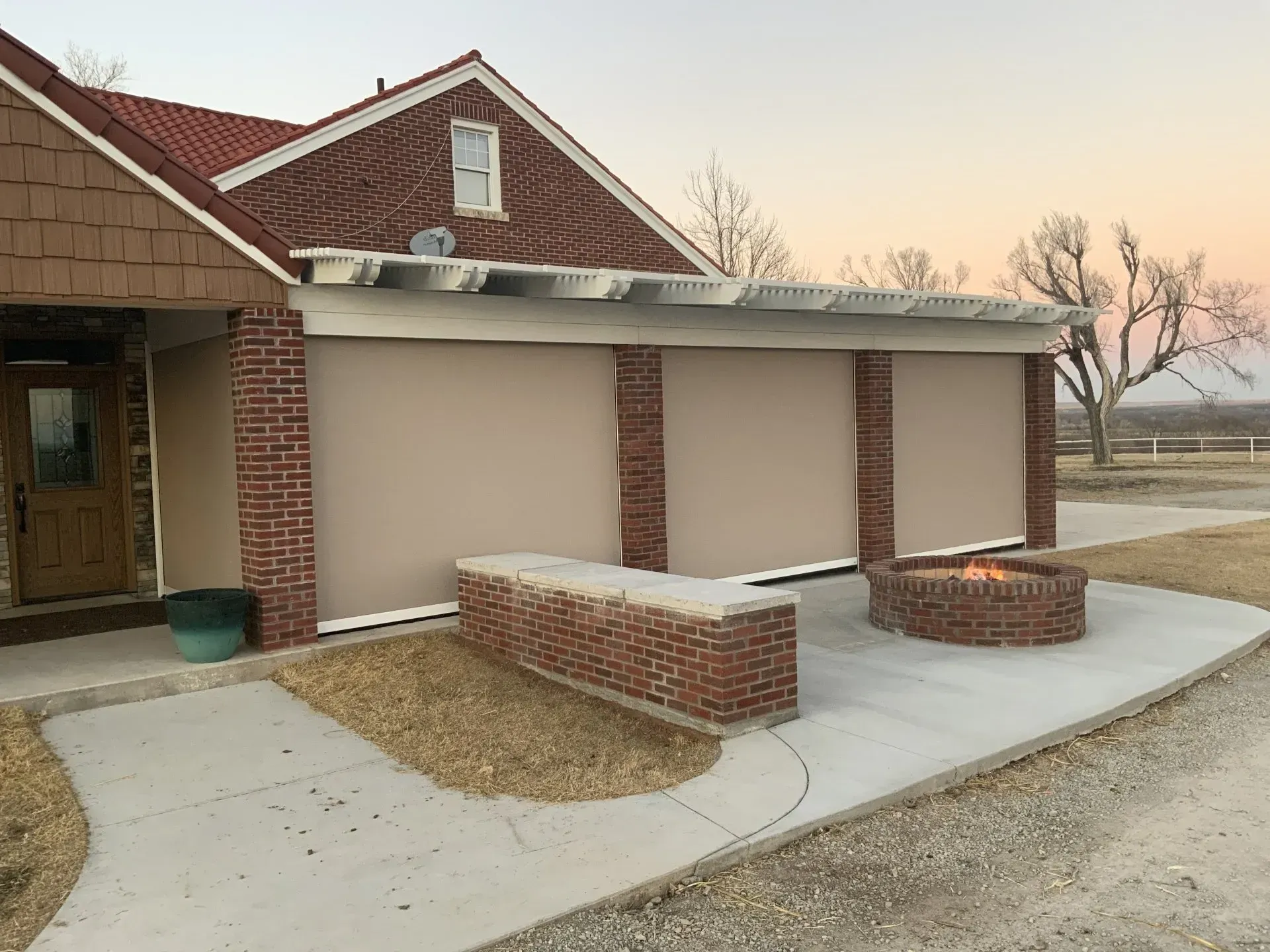 Brick building entrance with covered walkway, beige walls, and concrete ramp leading to the door