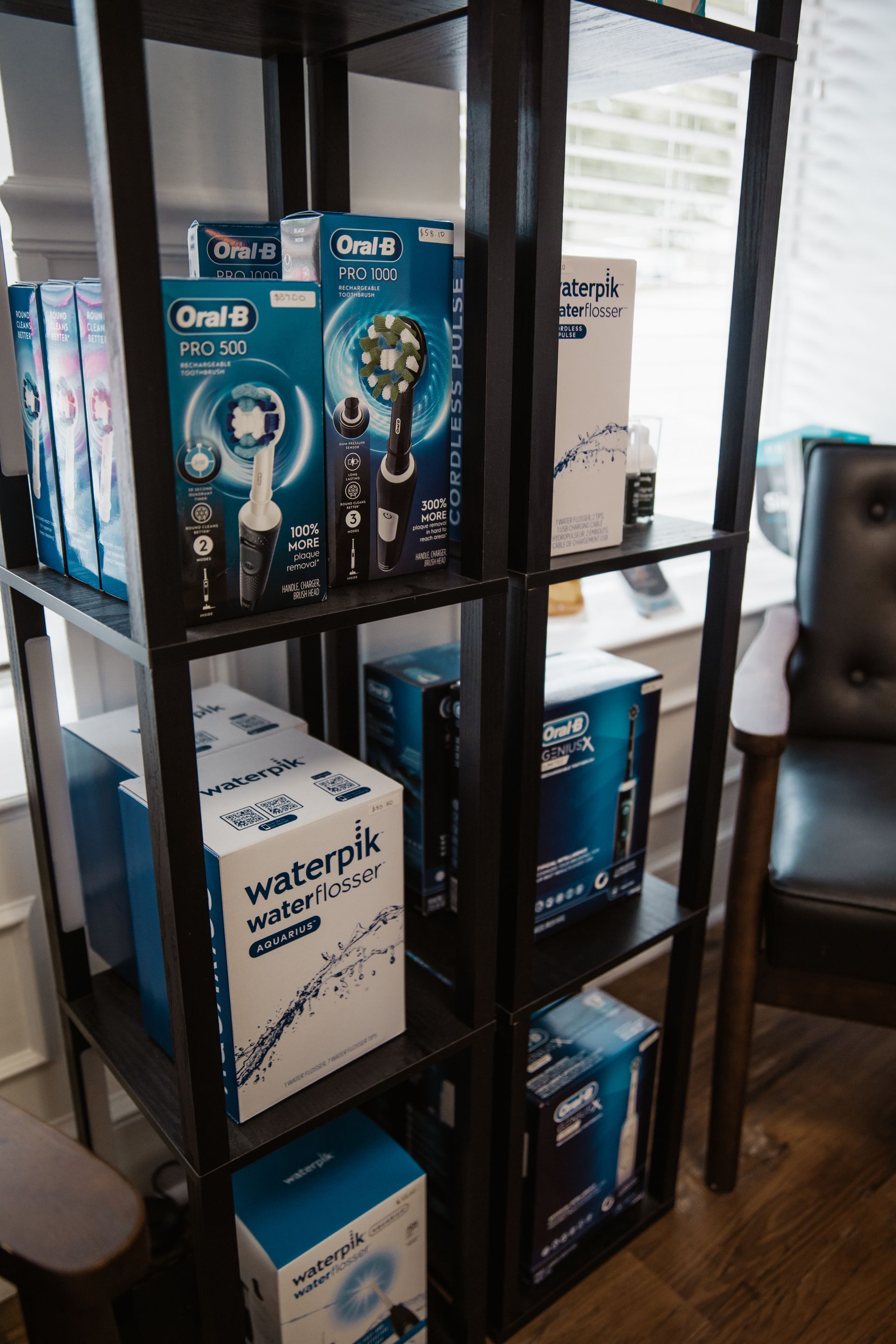 Shelves displaying dental hygiene products: Oral-B electric toothbrushes and Waterpik water flossers.