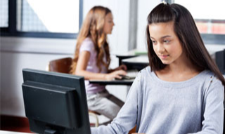 A teenage woman in front of her computer