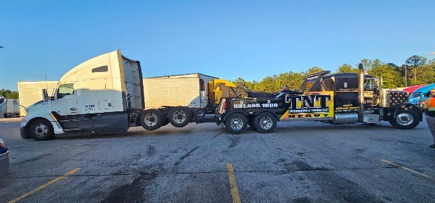 White semi-truck hauling a yellow dump trailer on a roadside under a blue sky