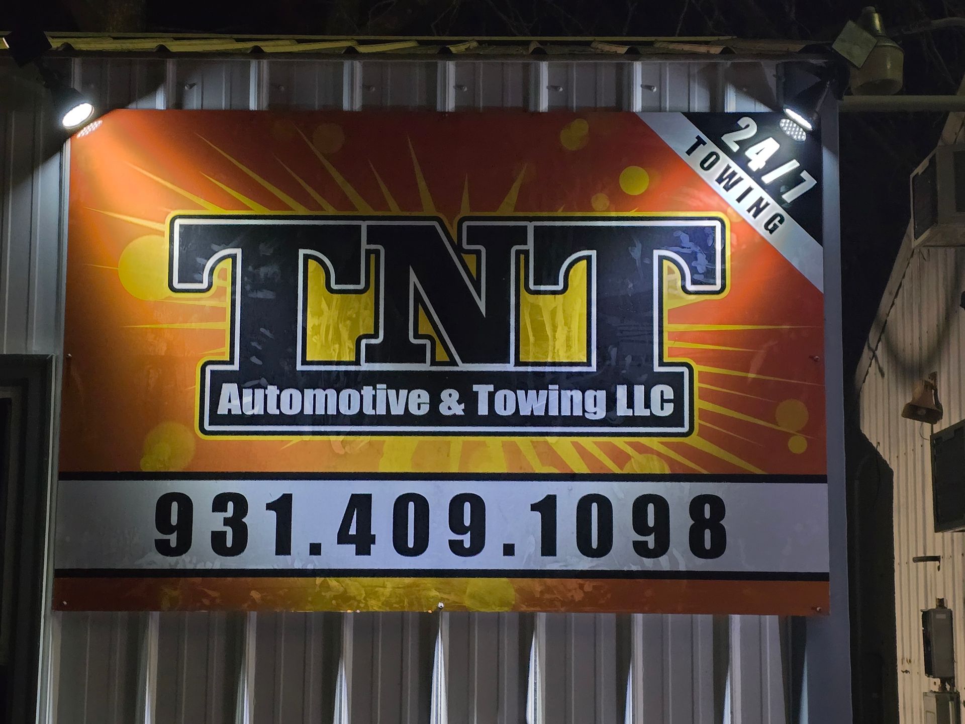 TNT Automotive & Towing LLC sign with phone number 931.409.1098 on a red-orange background.